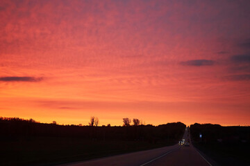 The highway and the sunset of an unusual color. Sunset before the storm.