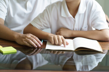 Asian father helps son to do her homework for the school..child study together homeschooling concept getting homework help from father