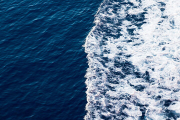 Ocean close up. Background of blue water with white foam.