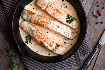 Cooked salmon fish with cream sauce in frying pan