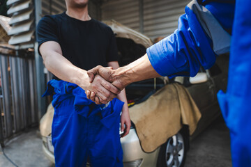 Auto mechanic handshake showing success collaboration of mechanics Check and maintain the engine for customers.