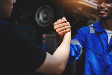 Auto mechanic handshake showing success collaboration of mechanics Check and maintain the engine...