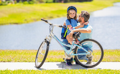 Obraz premium dad and son enjoying fun bike outing. dad and son on biking adventure. dad and son duo pedaling through picturesque landscape. supportive dad guiding his son first bike ride. Strong family bond