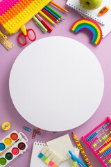 Fototapeta premium Classroom organization. Vertical top view of assortment of supplies: copybooks, pop-it pencil case, painting materials, abacus, apple on lilac backdrop, blank circle for text or promotional purposes