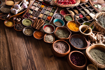Fototapeta na wymiar Spices. Collection of spices in bowls on wooden rustic table forming an abstract background.