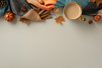 Above view of a warm and cozy autumn ambiance at home. Hot coffee, blanket, pumpkin candles, maple...