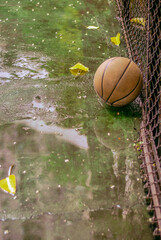 Basket ball on the ground in a park - Rainy day.