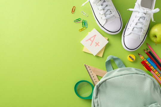 Inspire learners with this captivating overhead shot of school bag, sneakers and school supplies on light green backdrop. Enhance your educational content and advertisements with this image