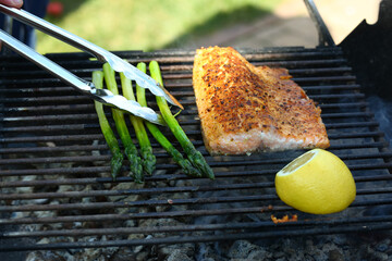 grilled salmon fish with spices lemon and asparagus stalk closeup photo