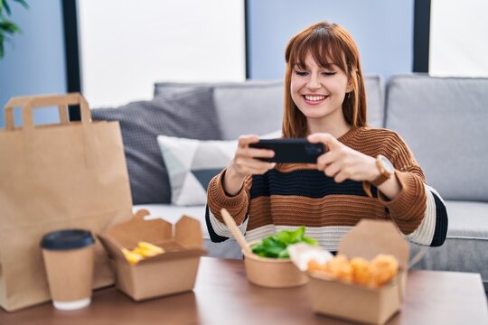 Young woman make photo by the smartphone to take away food at home