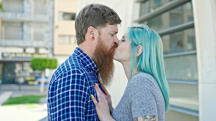 Fototapeta premium Man and woman couple standing together kissing at street