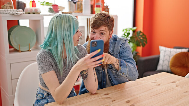 Man and woman couple smiling confident make selfie by smartphone at dinning room