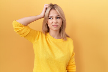 Young caucasian woman wearing yellow sweater confuse and wondering about question. uncertain with...