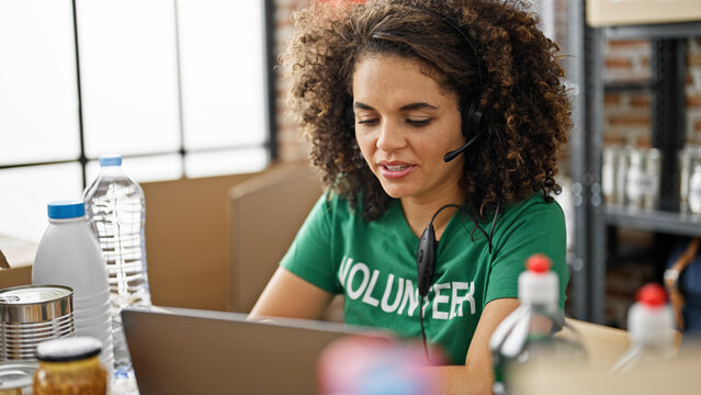 Young beautiful hispanic woman volunteer smiling confident having video call at charity center