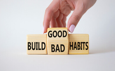 Build Good or Bad Habits symbol. Businessman hand turns wooden cubes and changes the words Build Bad Habits to Build good Habits. Beautiful white background. Business concept. Copy space