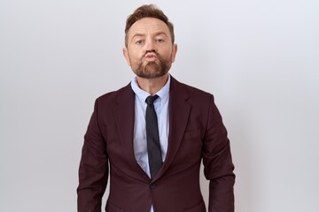 Middle age business man with beard wearing suit and tie looking at the camera blowing a kiss on air being lovely and sexy. love expression.