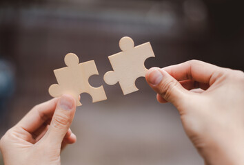 Business teamwork concept. Businessman holding a puzzle, business cooperation to achieve goals and objectives, efficiency and productivity, unity, brainstorming and problem-solving, creativity.