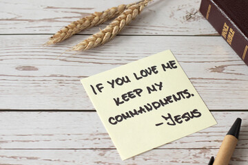 If you love Me, keep My commandments, Jesus Christ's words written in holy bible book with ripe wheat on wooden table. Close-up. Christian disciples obedience and faith in God, biblical concept. - obrazy, fototapety, plakaty