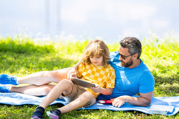 Fototapeta na wymiar childhood school education. son with father bonding in summer. family education of father and son kid. Father shapes son education. Father and son relax in park. Parent reading with child