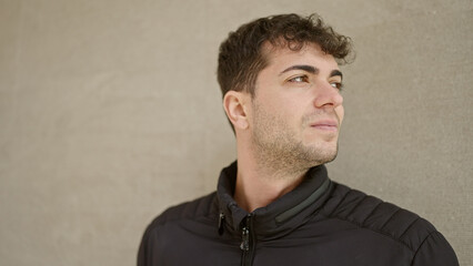 Young hispanic man standing with serious expression looking away over isolated white background