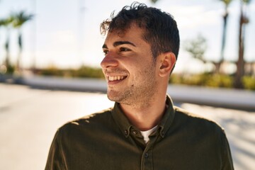 Young hispanic man smiling confident looking to the side at park