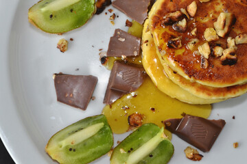 cheese pancakes and chocolate lie on a white plate