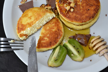 cut cheese pancakes lie on a white plate
