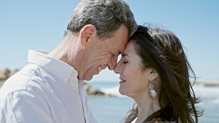 Fototapeta premium Senior man and woman couple smiling confident standing together at seaside