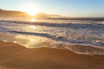 Fototapeta na wymiar Amanhecer no litoral do Rio de Janeiro, sol nascendo atrás da montanha