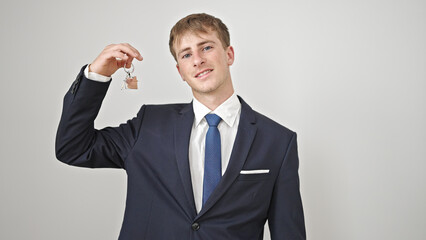 Young caucasian man real state agent holding keys of new home over isolated white background