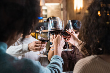 Multicultural Friends Toasting in Elegant Restaurant - Friends raising wine glasses in a toast,...