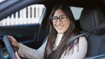 Young beautiful hispanic woman smiling confident driving car at street