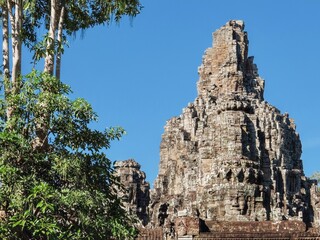 Fototapeta na wymiar Famous for its architecture, Bayon Temple in Cambodia on a sunny warm day, landscape.
