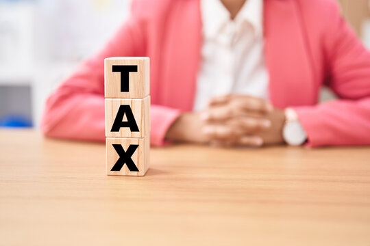 Business woman holding cubes with tax word on the table