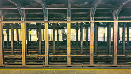 Train is stopped at the other end of the platform in a subway station in New York City.