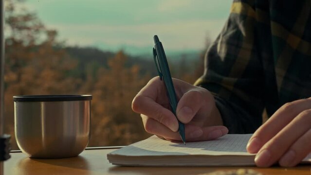 Tourist backpack, tourist woman emotionally Writes goals and plans in a diary against the backdrop of mountains and forests In the mountains. Fitness woman Morally rests from routine, winner

