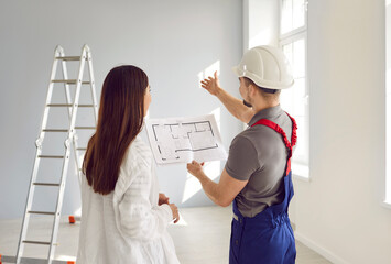 Builder and woman discussing renovation process in apartment. Rare view of foreman in hardhat and overalls meeting at home to talk about renovation process, interior decoration
