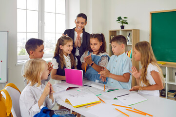 Happy children boys and girls have good time at school gaining knowledge and skills during class...
