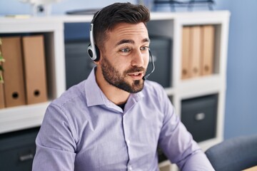 Young hispanic man call center agent working at office