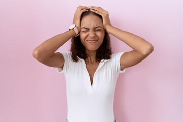 Young hispanic woman wearing casual white t shirt suffering from headache desperate and stressed...