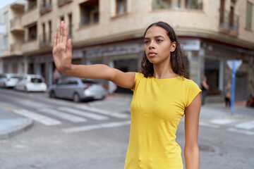 Fototapeta premium Young african american woman doing stop gesture with hand at street