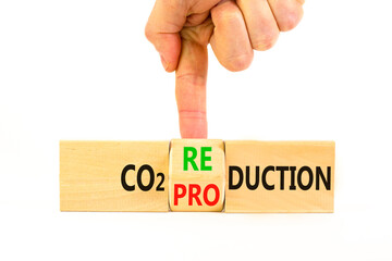 CO2 production or reduction symbol. Concept word CO2 production reduction on a wooden block on a beautiful white background. Businessman hand. Business ecological and CO2 changes concept. Copy space.