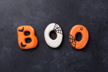 Text BOO from gingerbread cookies on dark stone background. Halloween concept