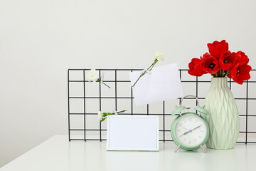 Decorated desk with clock, photo frame and flowers