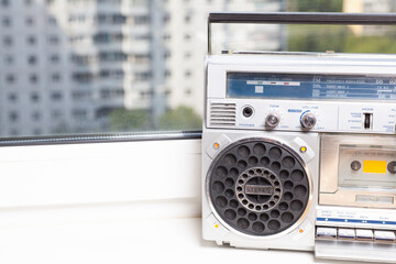 Silver retro ghetto radio boom box cassette recorder from 80s on the on window sills