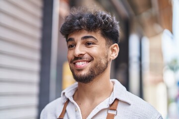 Young arab man waiter smiling confident looking to the side at street