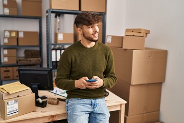 Young arab man ecommerce business worker using smartphone at office