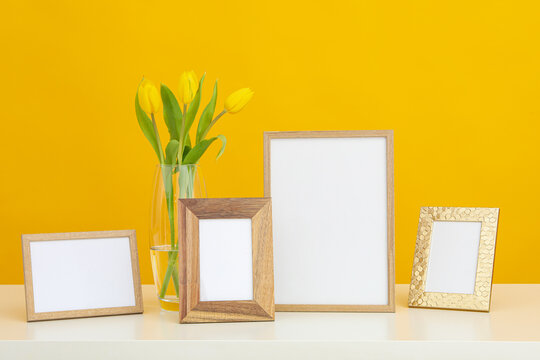 Photo frames with blanks on the table on a yellow background