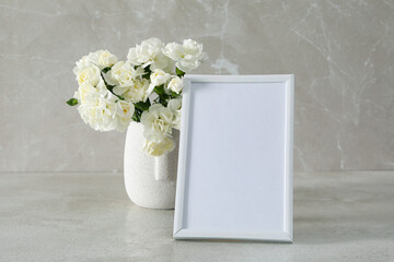 Photo frame with flowers on the table with empty space