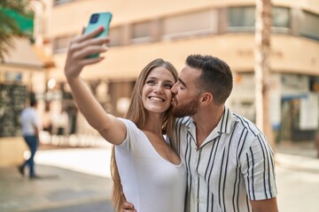 Man and woman couple smiling confident make selfie by smartphone at street